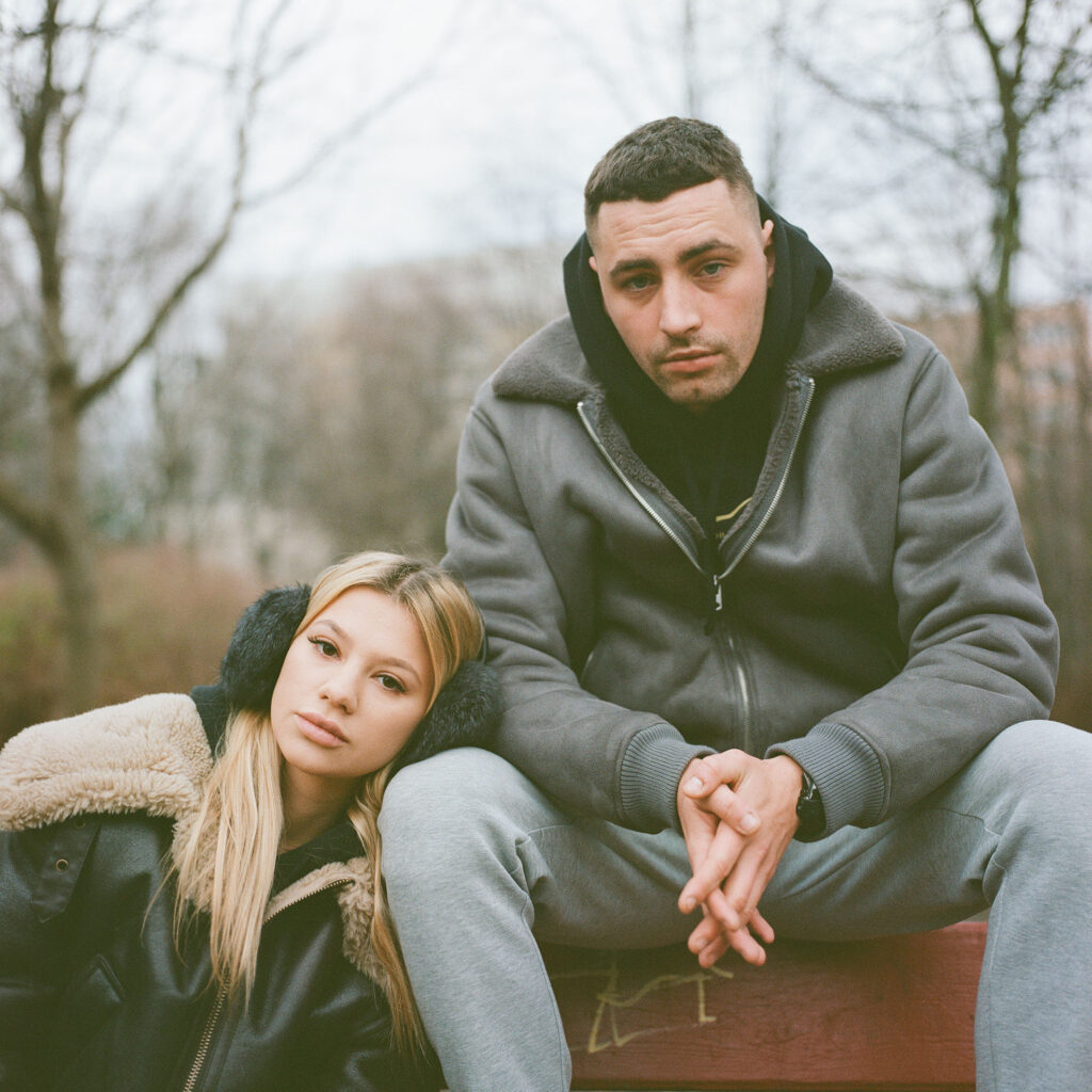 Two young people sitting close together, sharing a quiet, contemplative moment.