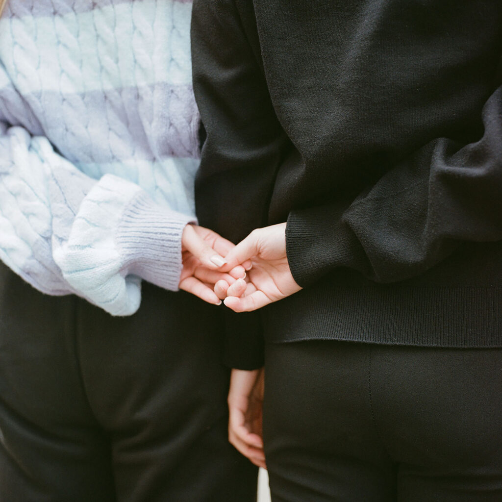 Close-up of two people holding hands, symbolizing intimacy and connection