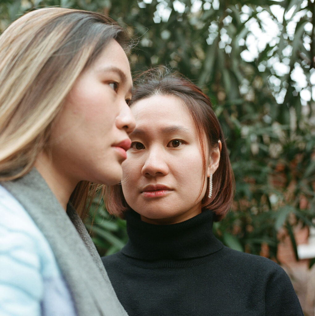 Two women standing closely, their faces conveying the depth of their connection.