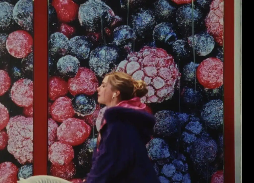 Addison Rae in front of frosted berries backdrop in vibrant scene from Headphones On video