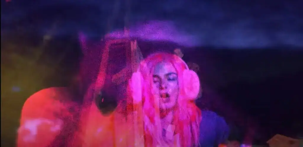Addison Rae wearing pink earmuffs in fantasy-like scene from Headphones On video