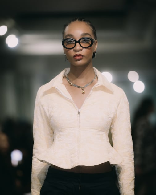 Portrait of a model while she walks, wearing a white shirt and sunglasses