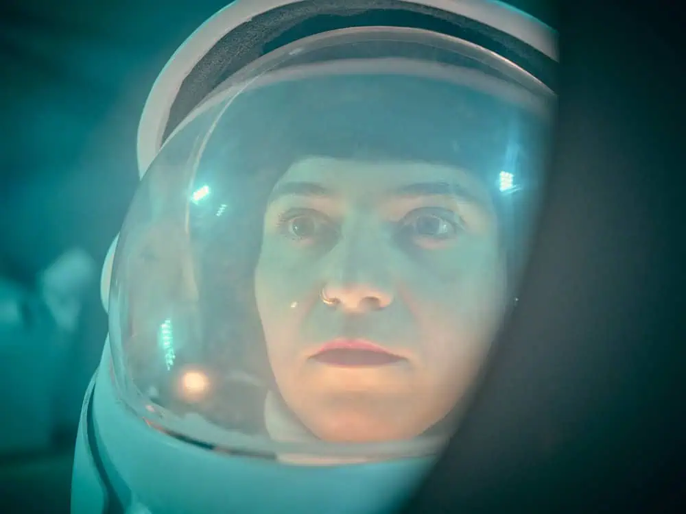 Close-up of Nelly Ben Hayoun-Stépanian wearing a space helmet in immersive documentary scene