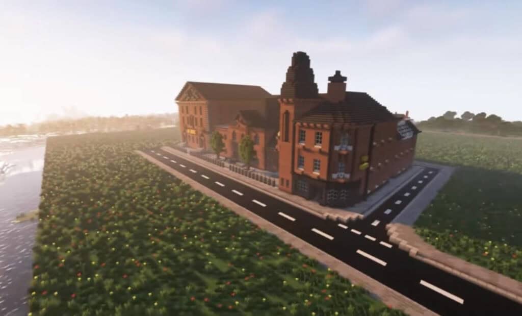 Pixelated Minecraft-style buildings alongside a paved road and flower fields, with a hazy sky in the background