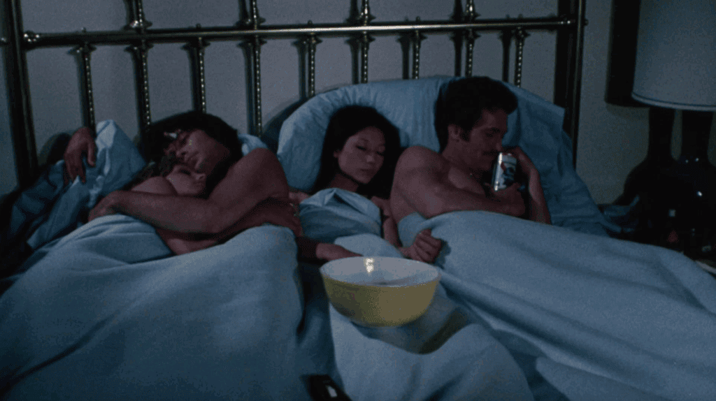 Scene from a Stephanie Rothman-directed film: four adults share a large bed, suggesting themes of sexual freedom and critique of traditional taboos.