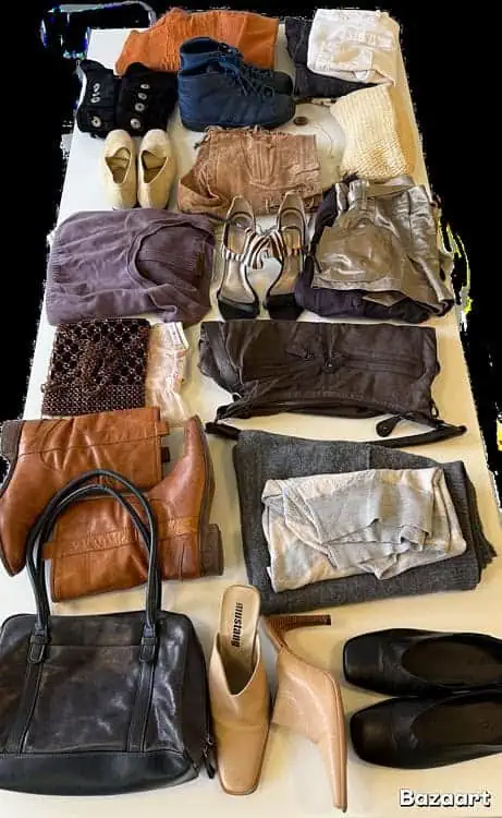 Organized layout of neutral-toned second-hand clothing, shoes, and bags displayed on a white surface