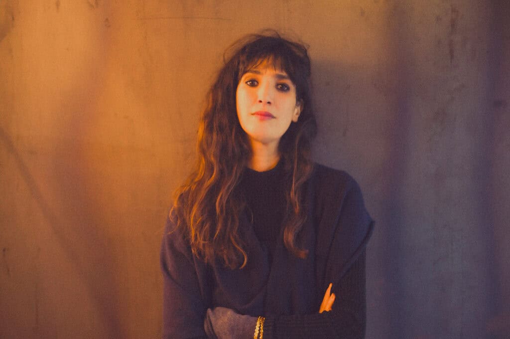 Portrait of playwright and director Caroline Guiela Nguyen, creator of the theatre production LACRIMA exploring the unseen labour behind luxury fashion.