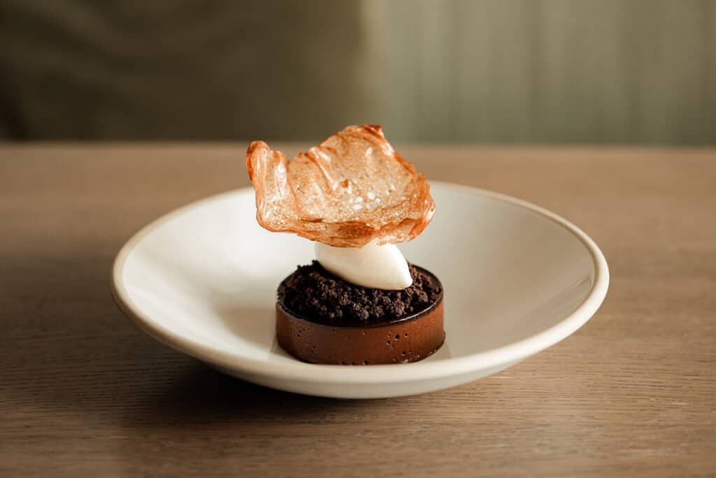 Refined chocolate dessert with crisp tuile and cream, served at The Silver Birch.