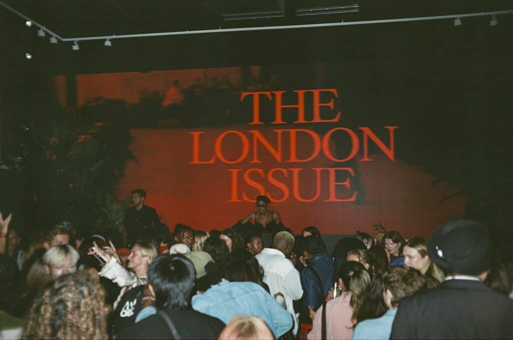 Crowd dancing under “The London Issue” sign at H&M London Fashion Week event.