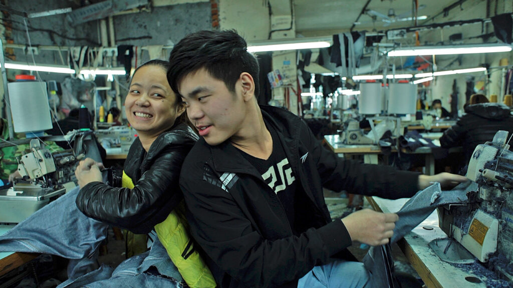 Young garment workers smiling in Zhili textile factory, Wang Bing’s Youth (Spring).