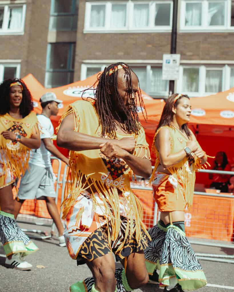 Dancers in yellow fringe costumes performing at Notting Hill Carnival.