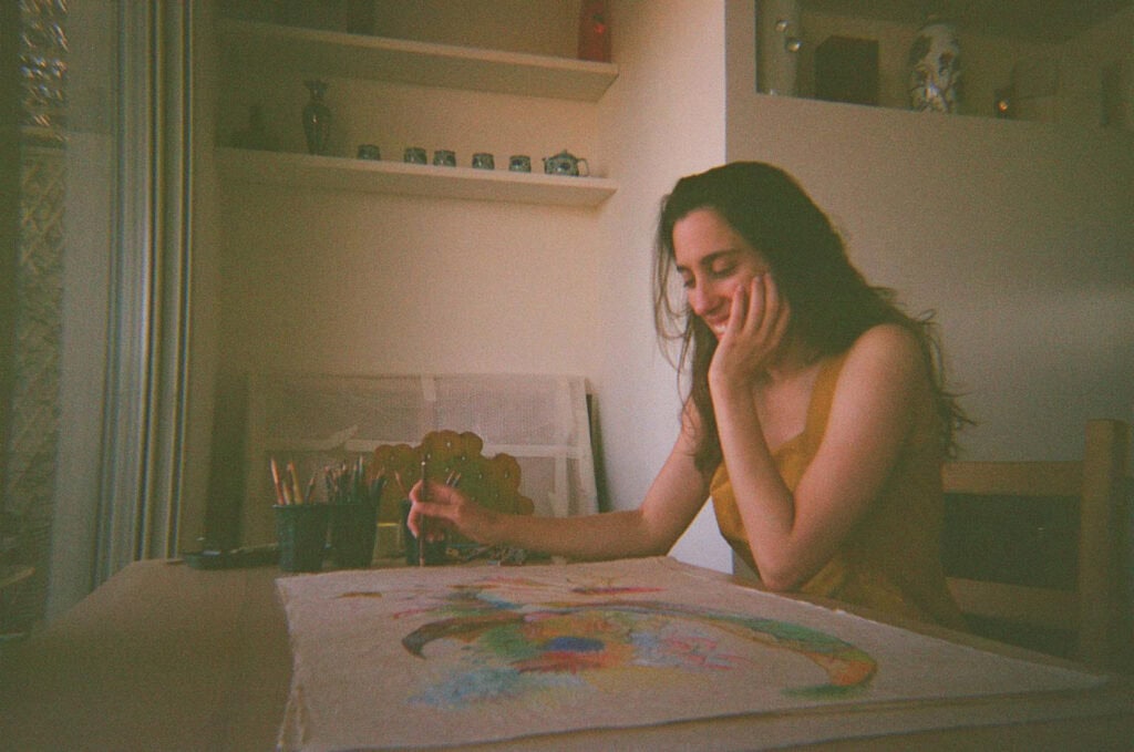 Valentina Bartolini painting in her studio, working on a surrealist pastel piece from her Studio Meditation collection.