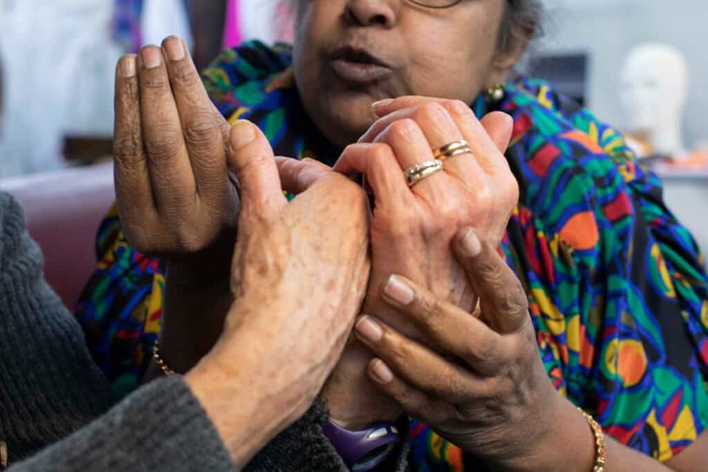 Close-up of two women’s hands in conversation, symbolizing craftsmanship, collaboration, and shared storytelling in LACRIMA.
