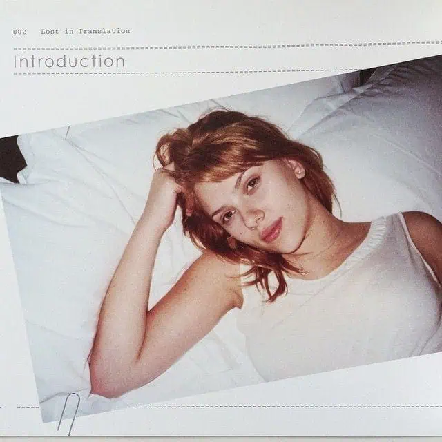 Archival image from Lost in Translation showing a woman lying on a bed in a white tank top, looking into the camera with a soft expression.