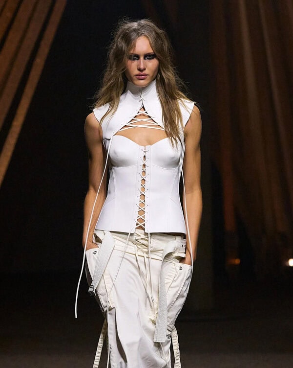 Alexander McQueen SS26 white cut-out corset top styled with slouchy white cargo trousers.