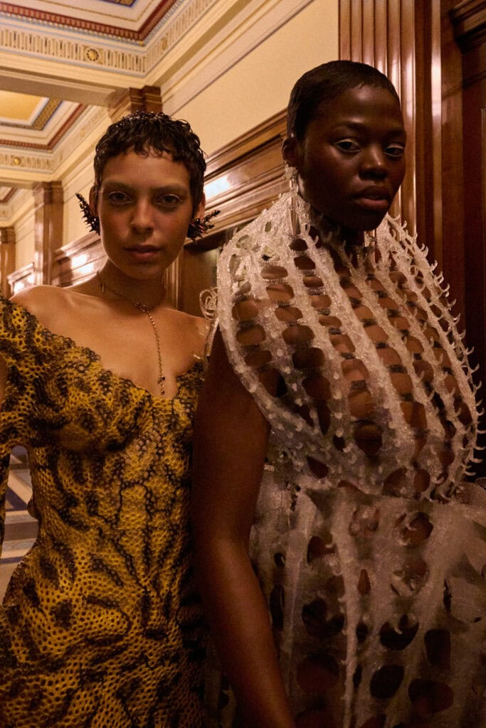 Two models wearing tactile biomorphic dresses from Karina Bond SS26 showcasing contrasting woven and lattice textures.