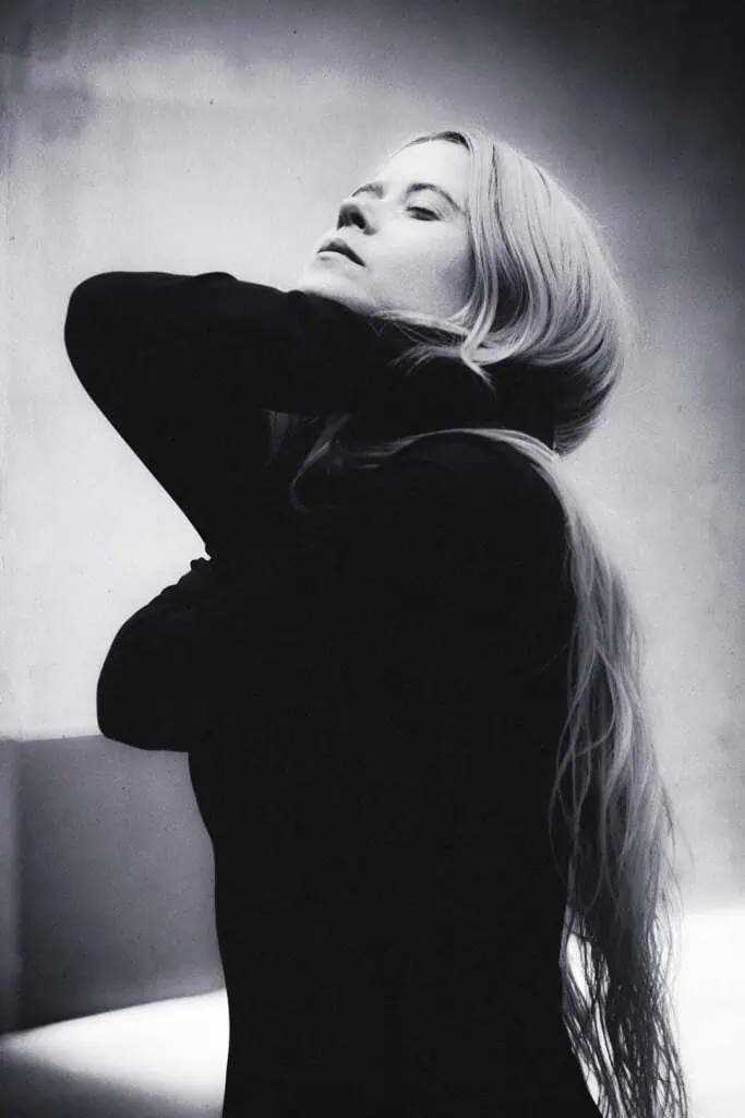Black and white portrait of Anna von Hausswolff with closed eyes and hands around her neck, intimate and dramatic photograph for Cold Magazine ahead of her album “ICONOCLASTS”.
