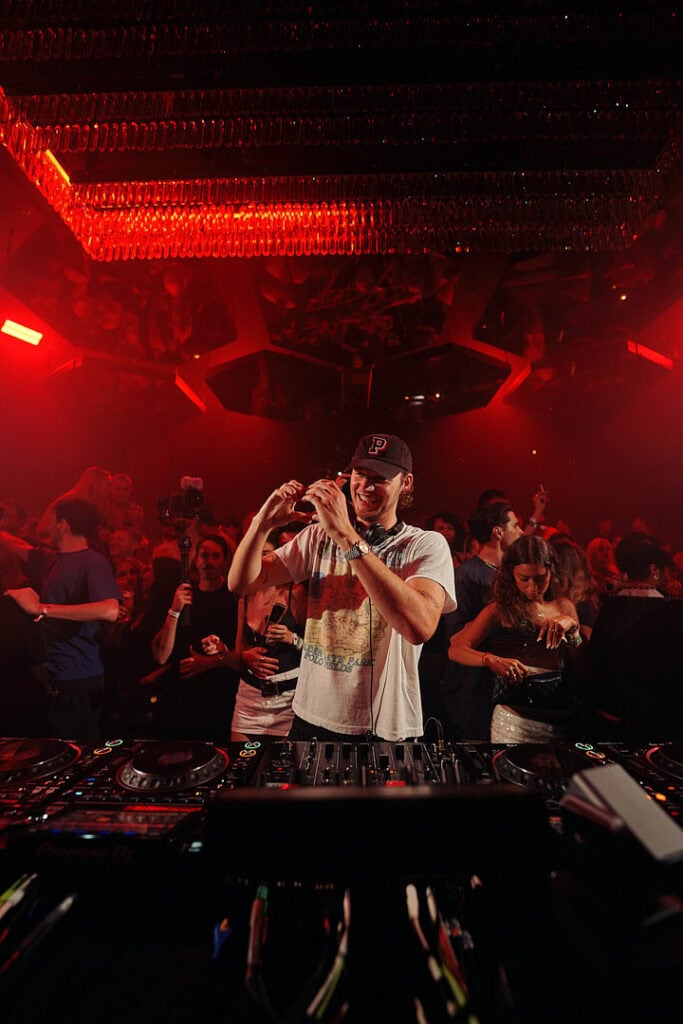 Mau P performing in front of a vibrant crowd bathed in red light, photograph from his Pacha Ibiza residency accompanying Cold Magazine’s “Mau P: The Internet’s Favourite DJ” article.