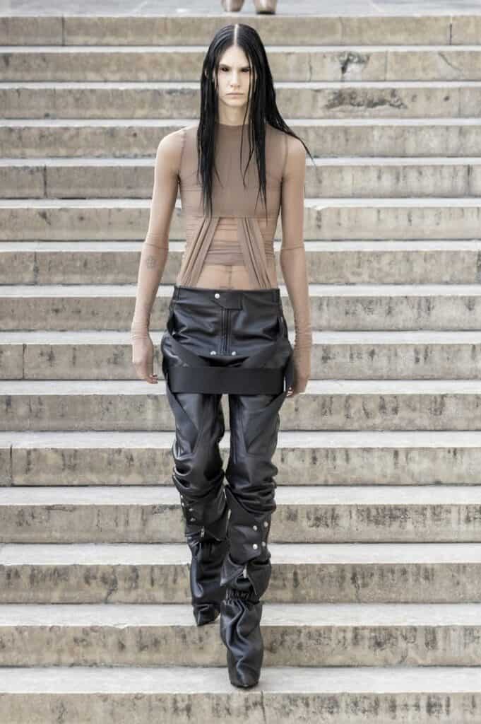 Rick Owens SS26 nude mesh top with exposed corset seams paired with black vinyl skirt.