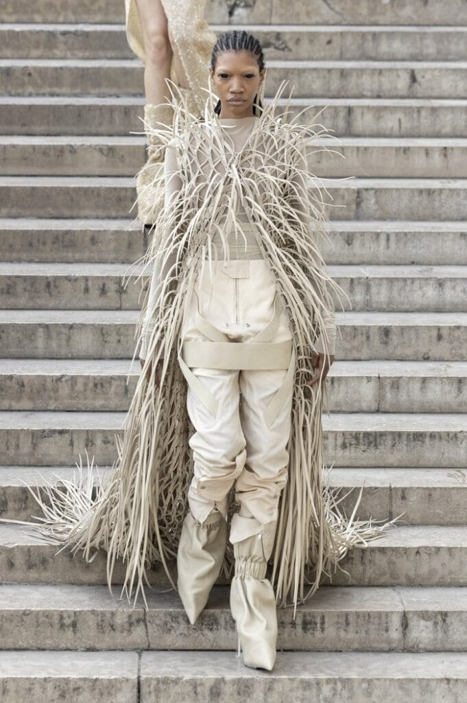 Rick Owens SS26 cream look featuring layered fringe textures and sculptural stacked boots.