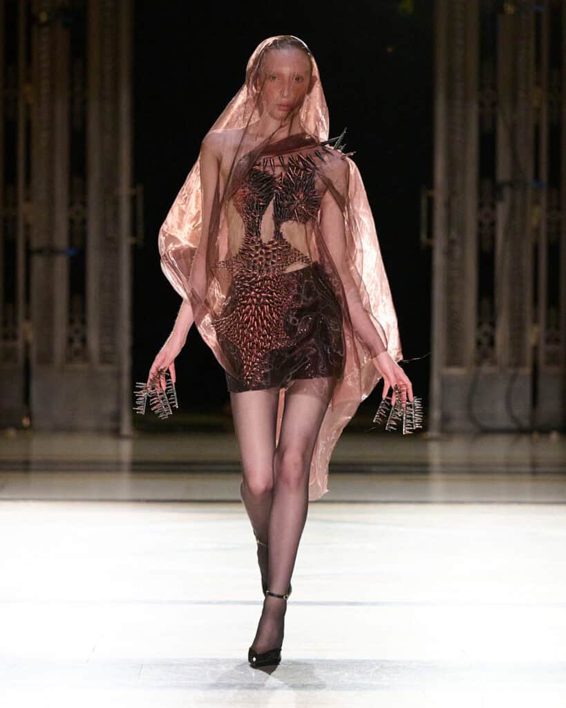 Veiled carapace-style dress from Karina Bond SS26 with semi-transparent layered materials and sculptural silhouette.