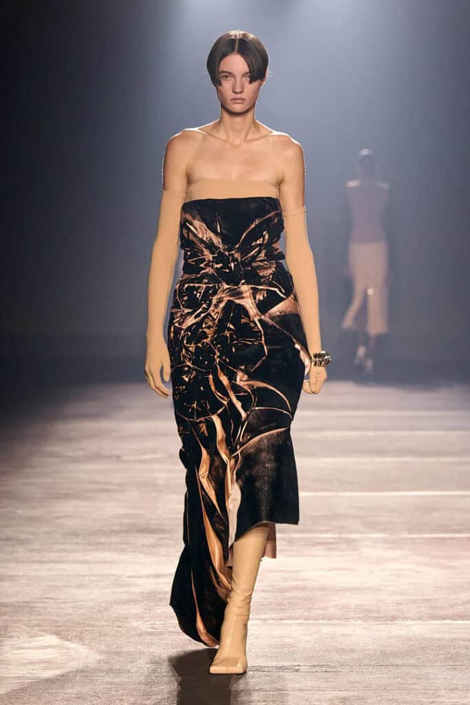 Mugler SS26 strapless black dress with gold abstract marbled pattern and fluid draping.