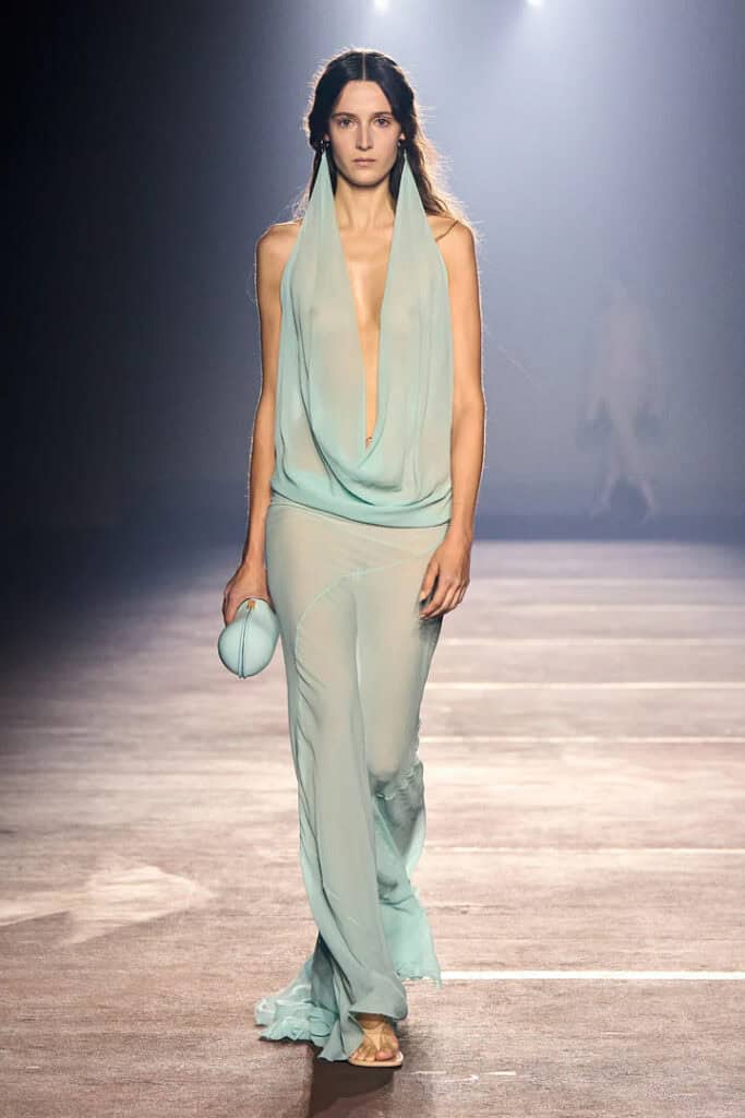 Mugler SS26 aqua draped dress with plunging neckline and matching satin clutch.