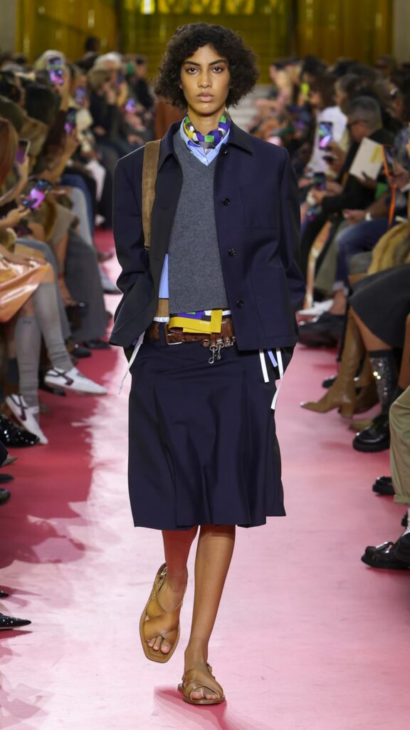 Miu Miu SS26 navy tailored set with layered grey vest and belted waist.
