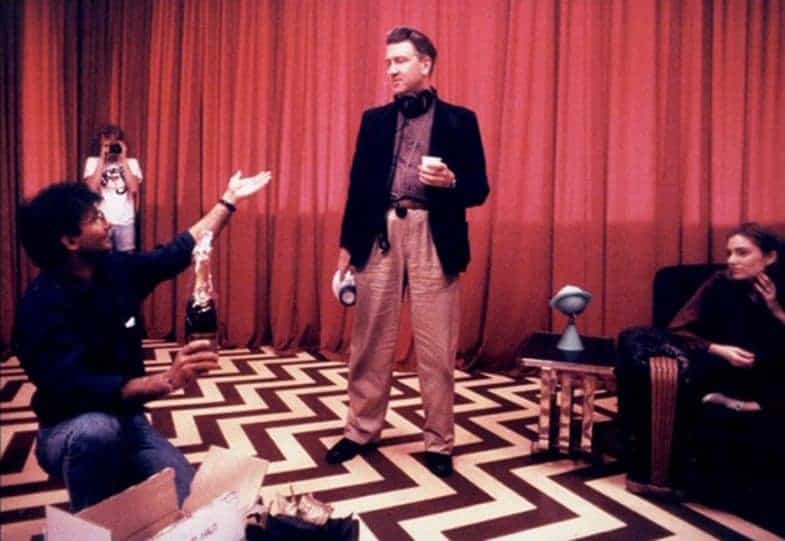 Scene from the Red Room in Twin Peaks, featuring zigzag black-and-white flooring and heavy red curtains.