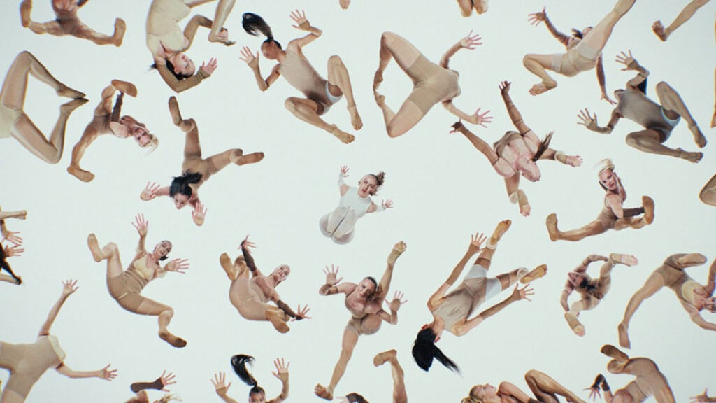 Dancers falling in surreal formations against a white background in Bonnie Banane’s dystopian music video ‘Hoes of Na’.