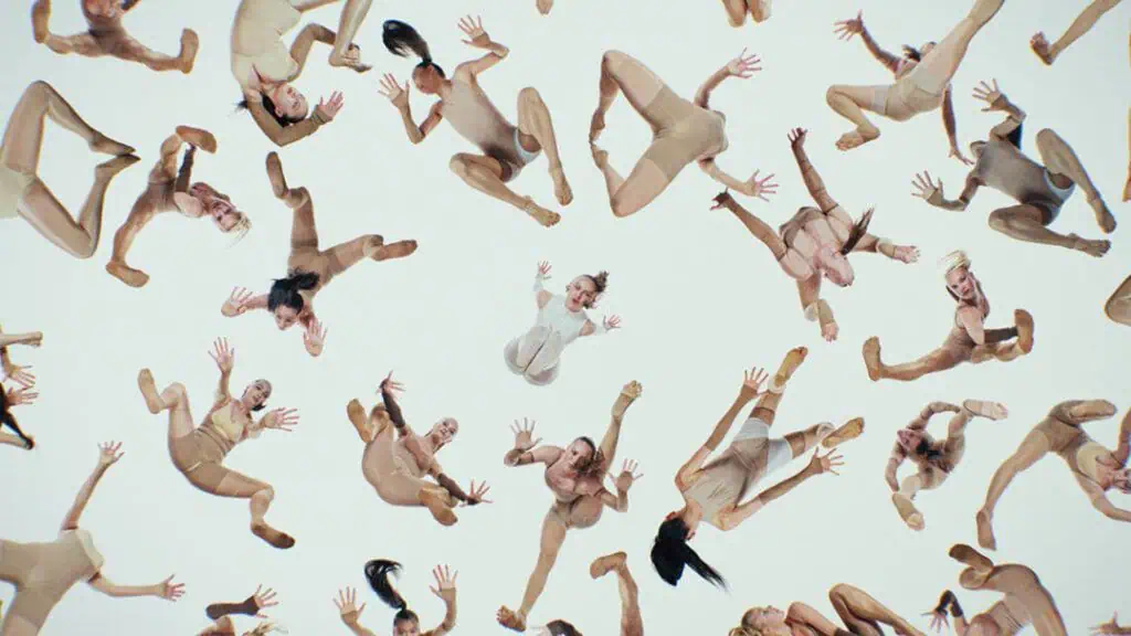 Dancers falling in surreal formations against a white background in Bonnie Banane’s dystopian music video ‘Hoes of Na’.