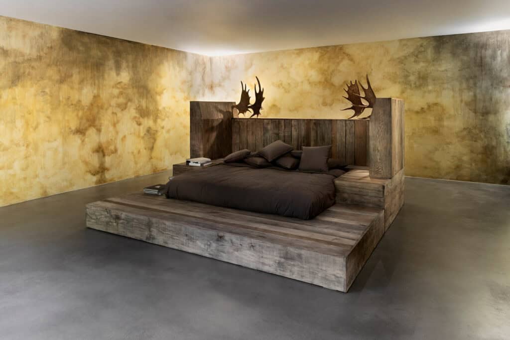 Massive wooden bed with moose antlers designed by Michele Lamy and Rick Owens for Rust Never Sleeps, reflecting the couple’s raw, hedonistic aesthetic.