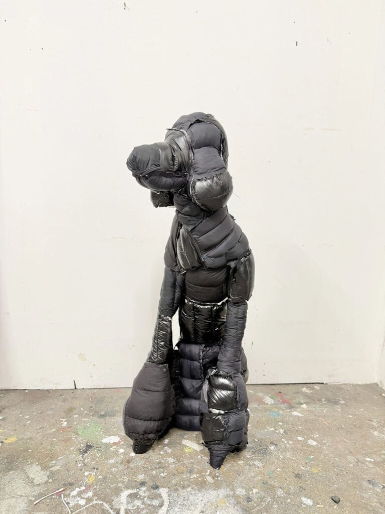 Standing dog sculpture made from black puffer-jacket material in Yutaro Inagaki’s studio.