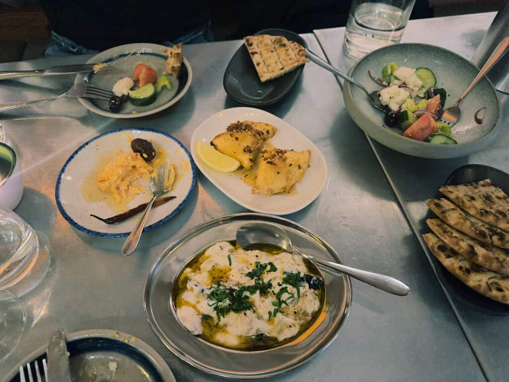 A selection of Greek small plates at Vori, including pita, tirokafteri, Greek salad, and filo pastries.