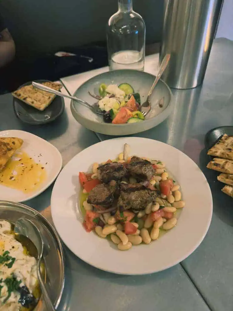 Greek lamb dish served over white beans with chopped tomatoes and olive oil at Vori in Holland Park.
