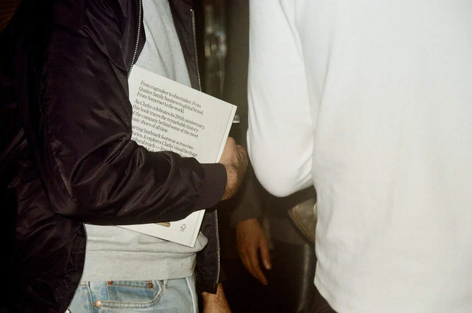 Close-up of a guest holding the “Clarks: 200 Years” book by Alexander Newman at the brand’s historical celebration event.