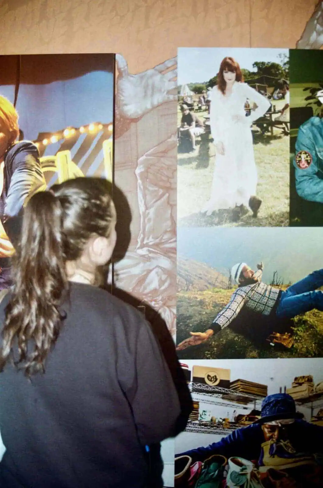 A visitor observing a wall of archival Clarks images showcasing the brand’s cultural history and iconic designs.