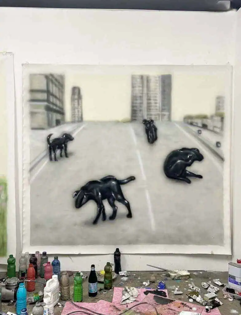 Large painting of glossy black dog-like creatures wandering through an empty urban landscape in Inagaki’s studio.