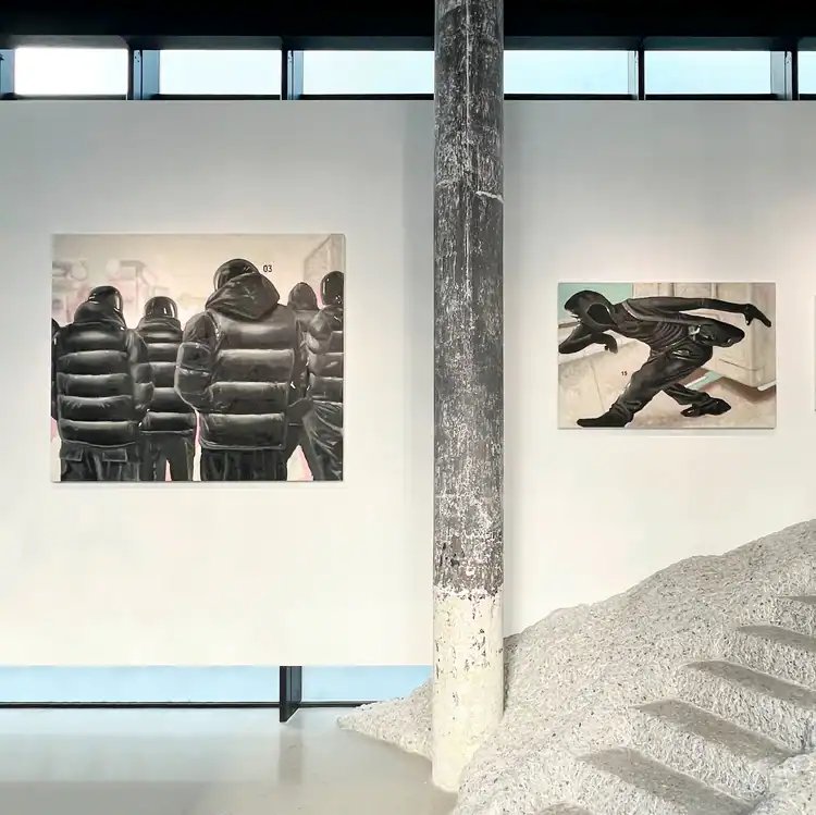 Gallery installation view of Yutaro Inagaki’s paintings of black puffer-clad figures displayed on a white wall.