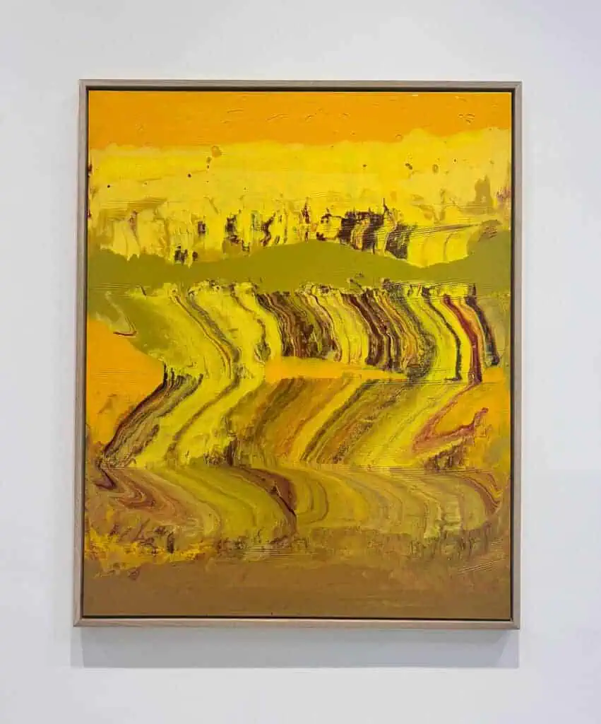 A framed abstract painting features swirling strokes of yellow, gold, brown, and hints of green, creating a wavy, textured pattern resembling a dynamic landscape—an eye-catching piece perfect for display during Miami Art Week 2025.