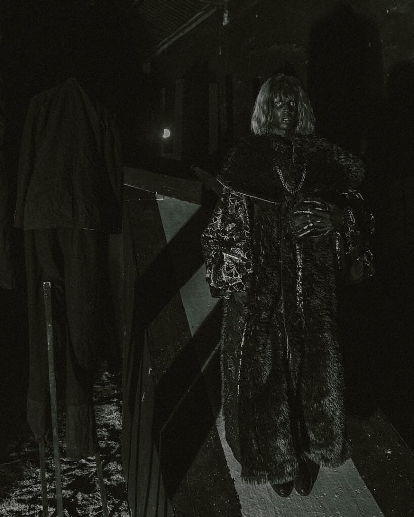 Dramatic monochrome editorial portrait in an industrial setting, evoking the experimental visual world associated with musician KABEAUSHÉ.