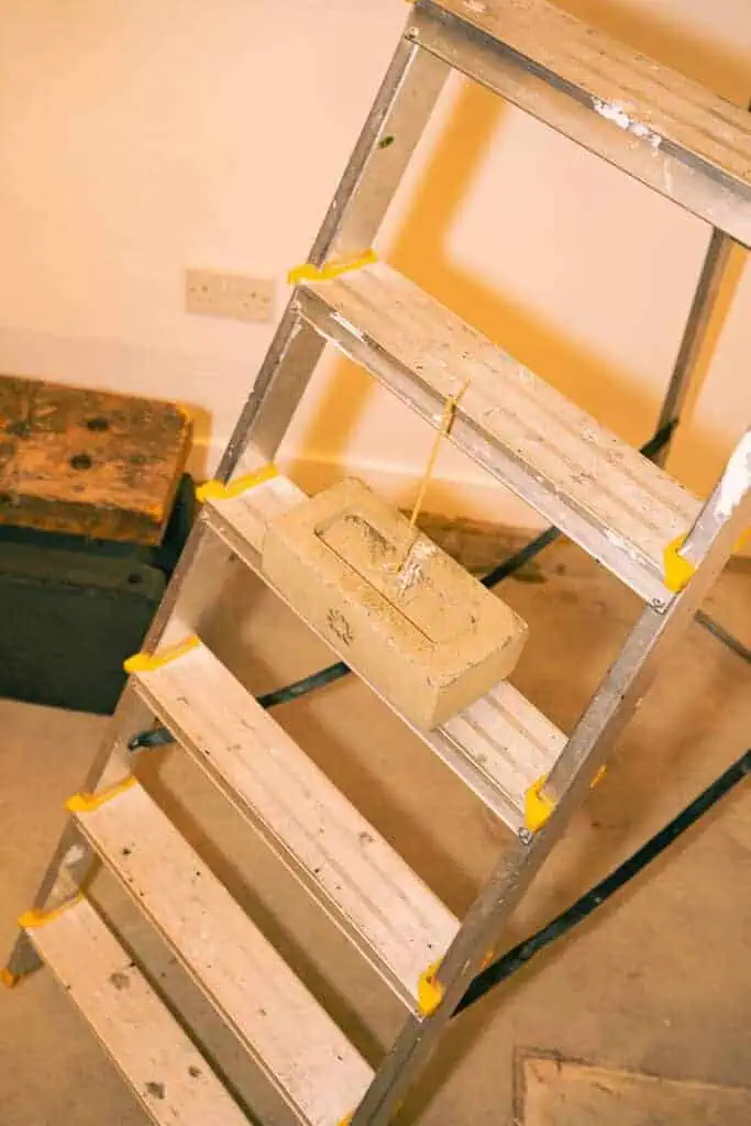 Detail of the raw, work-in-progress setup inside Gander’s AW25 showcase, featuring a ladder and concrete block.