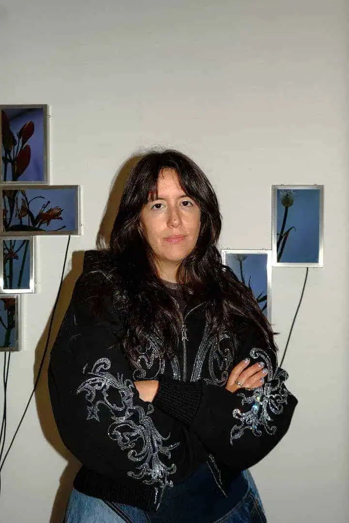 Portrait of artist Julieta Tarraubella standing in front of her audiovisual flower installation.