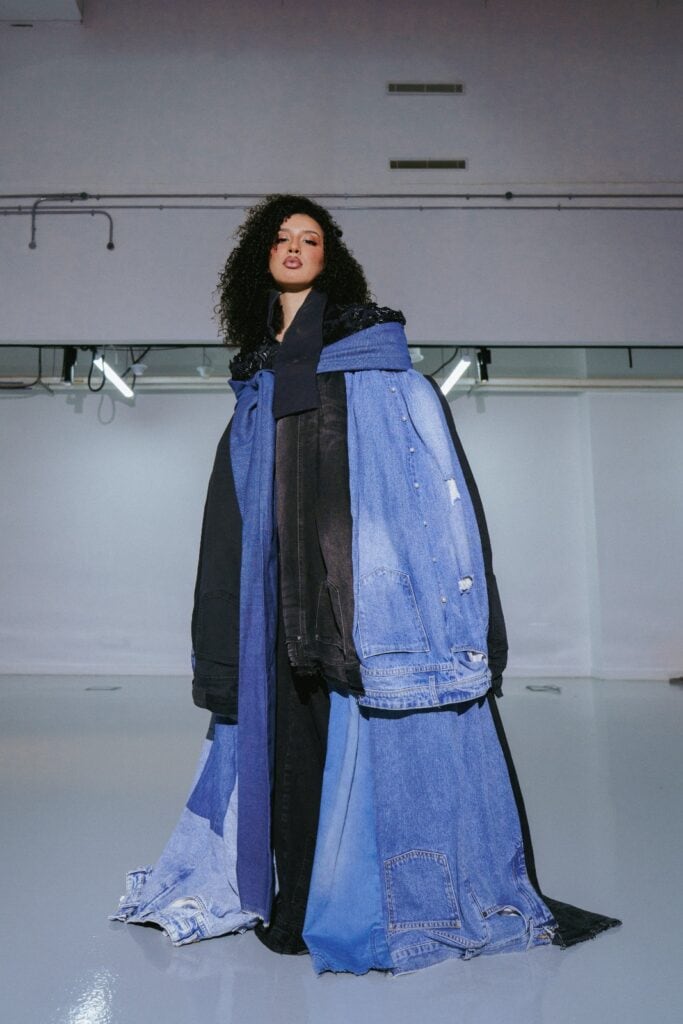 Model showcasing Samah Sulyman’s dramatic floor-length patchwork denim coat.