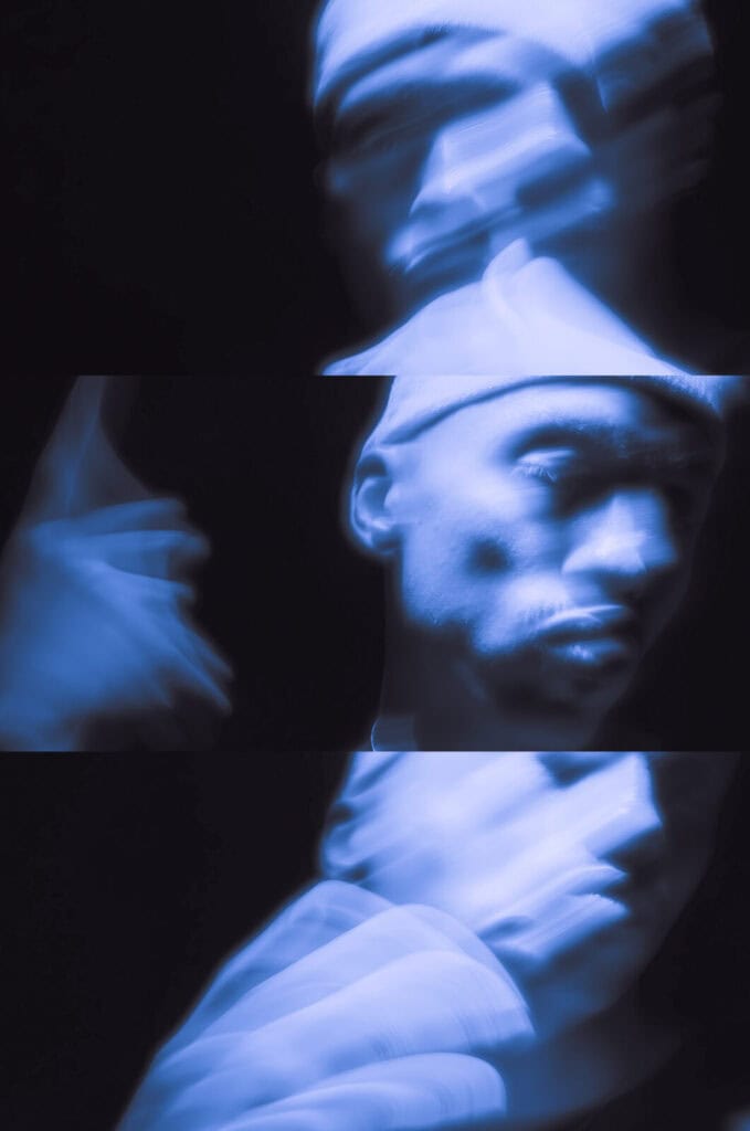 A blurry, blue-toned image is split into three horizontal sections. Each section shows a person’s face and upper body in motion, creating a ghostly, abstract effect against a dark background.