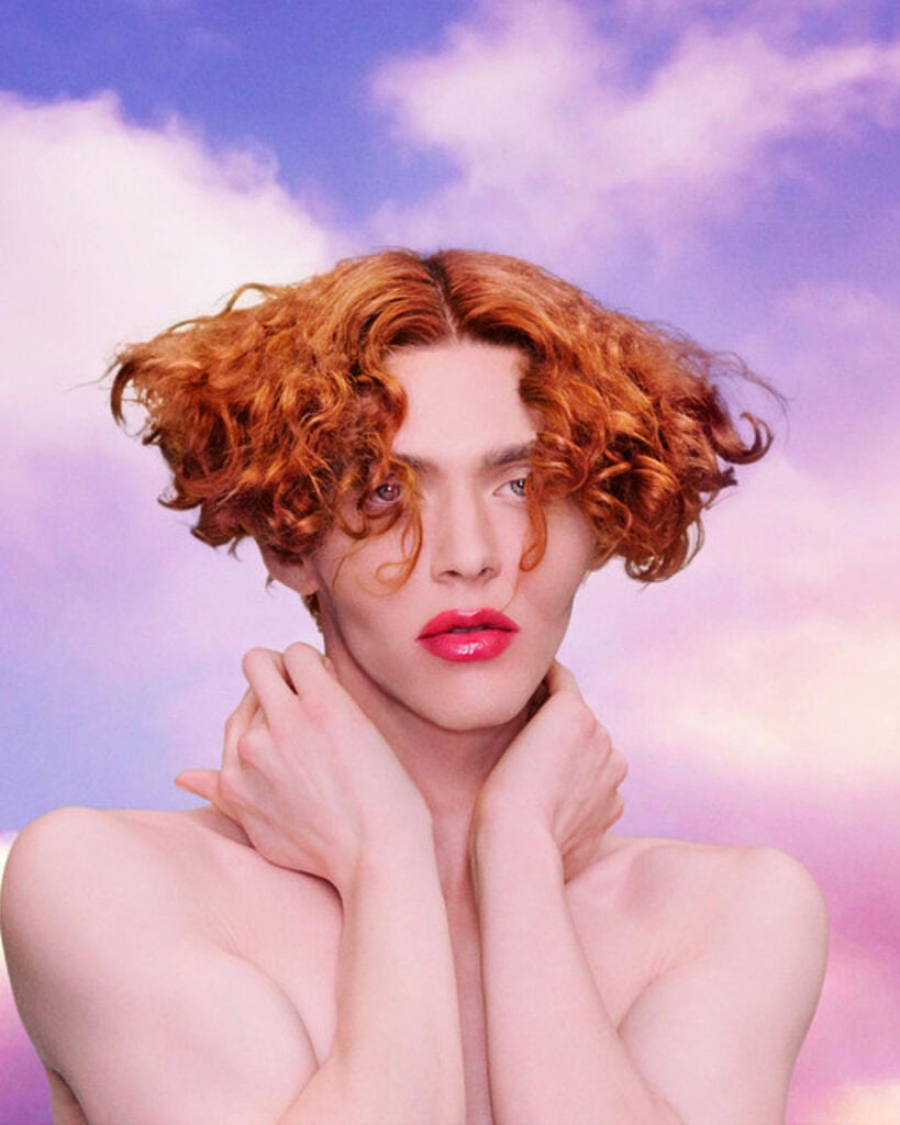 A person with red hair and pink lipstick, channeling the bold and vibrant style of SOPHIE.