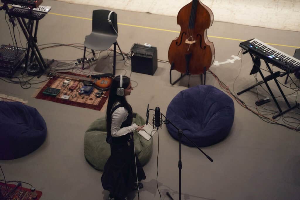 Musician BODUR captured in a creative moment, utilizing NOTHING(R) headphones.