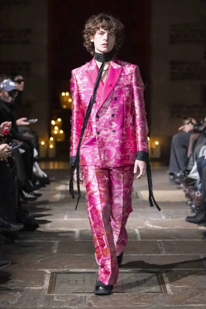 Model presenting a vibrant pink patterned double-breasted suit by John Richmond on the catwalk
