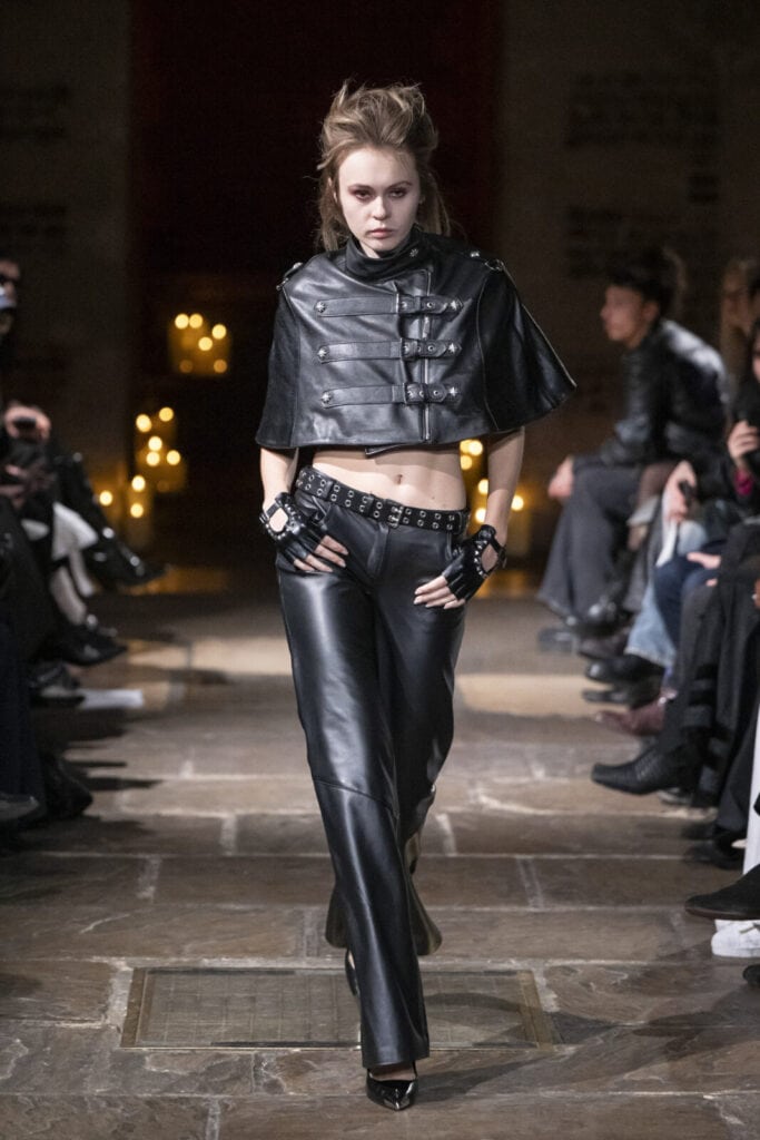 Model showcasing a punk-inspired look with a leather cropped cape and leather trousers by John Richmond