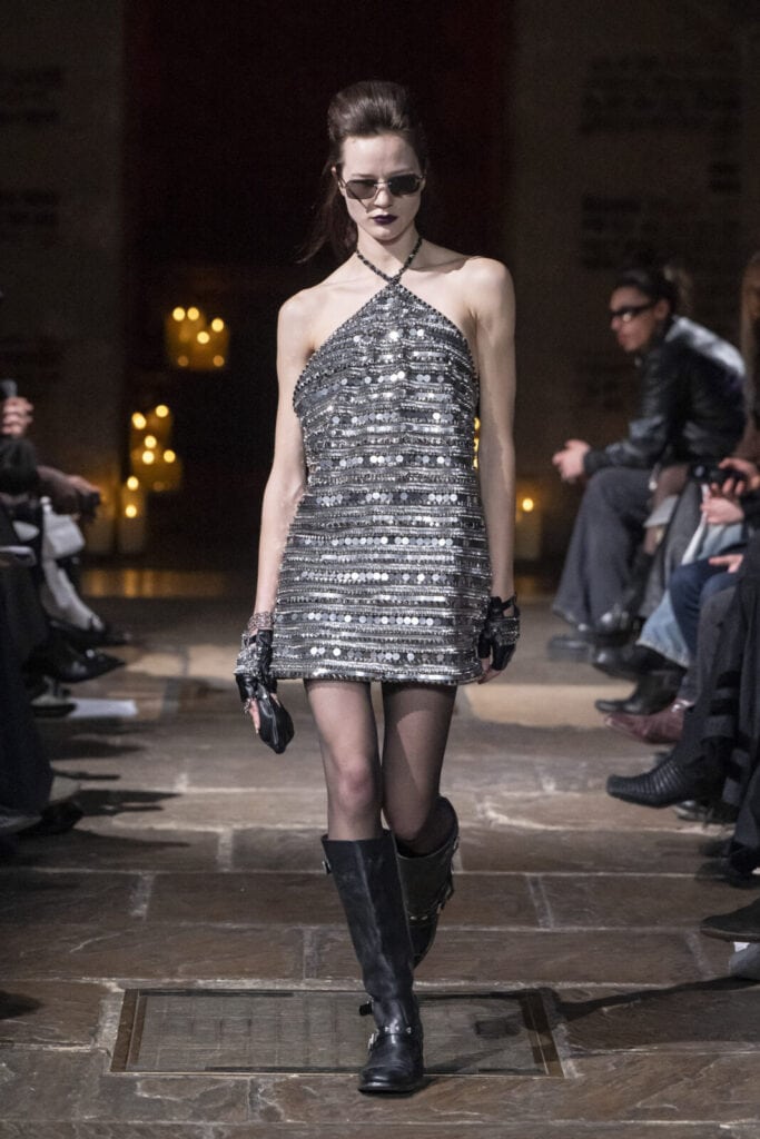 Model on the runway in a silver sequined halter-neck mini dress for John Richmond